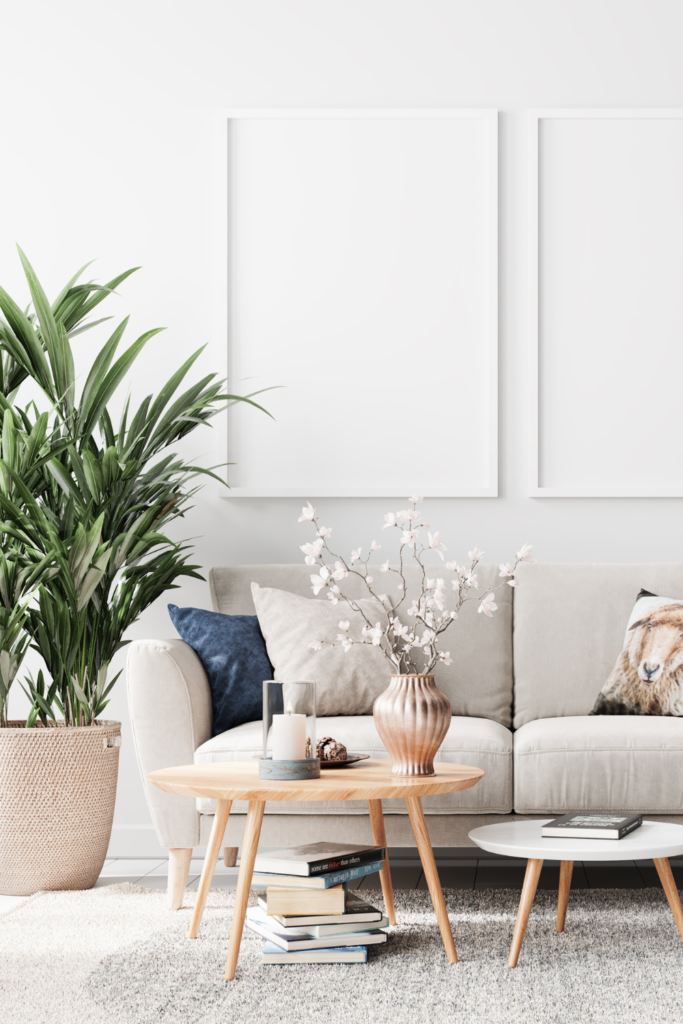 Stock Photo from Canva by JP_3D of a light coloured living room and grey couch with a wood coffee table in the centre