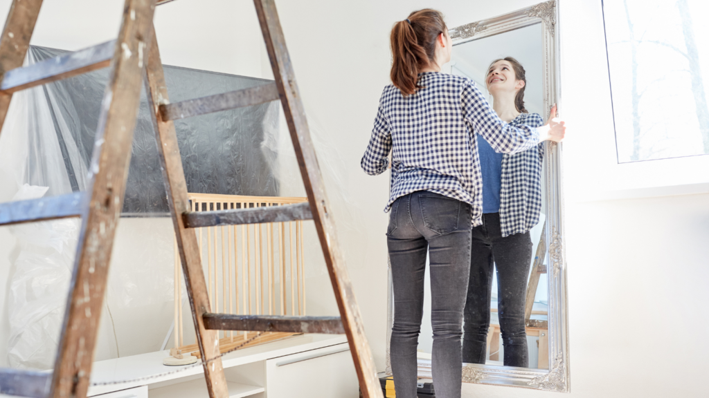 Stock photo from Canva by Robert Kneschke of a woman handing up a mirror in her home