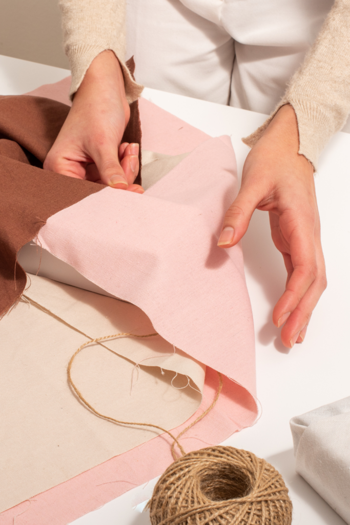 Stock photo from Canva by Stefano Oppo of a woman wrapping a gift in pink and brown cloth