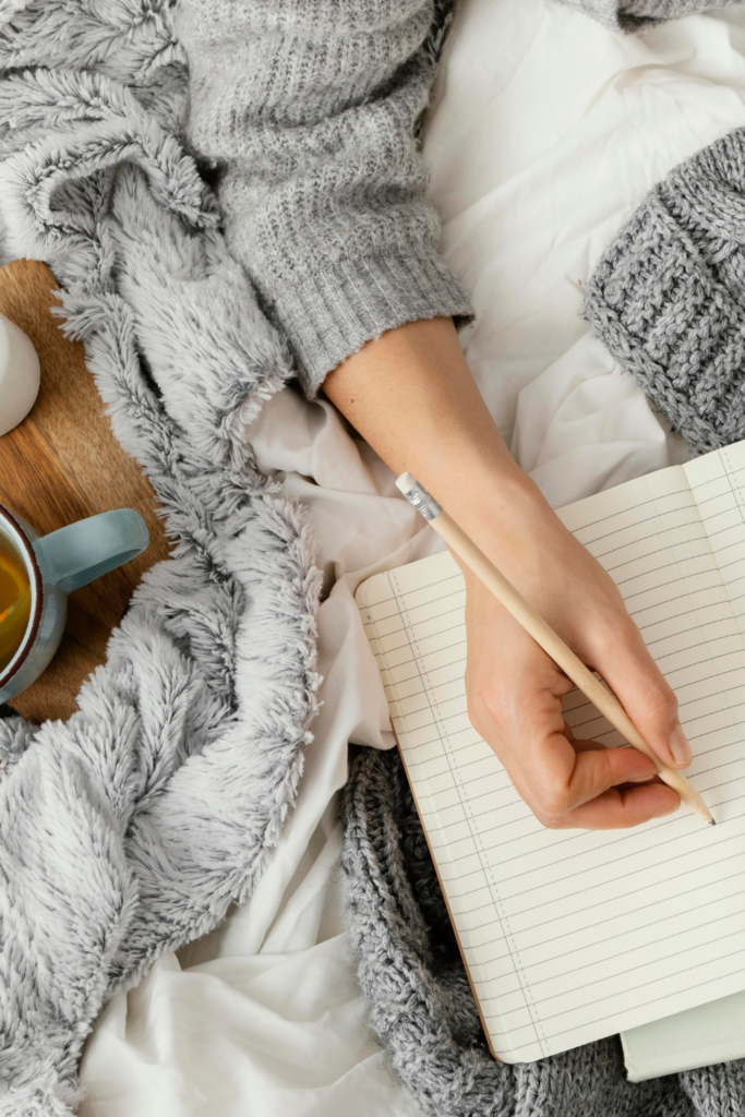 Stock Photo from Canva by Paul Tama's of someone writing in a journal