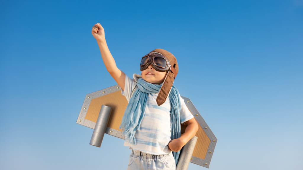 Stock photo from Canva by Sunny Studio of a child dressed up as a pilot with cardboard wings on his back