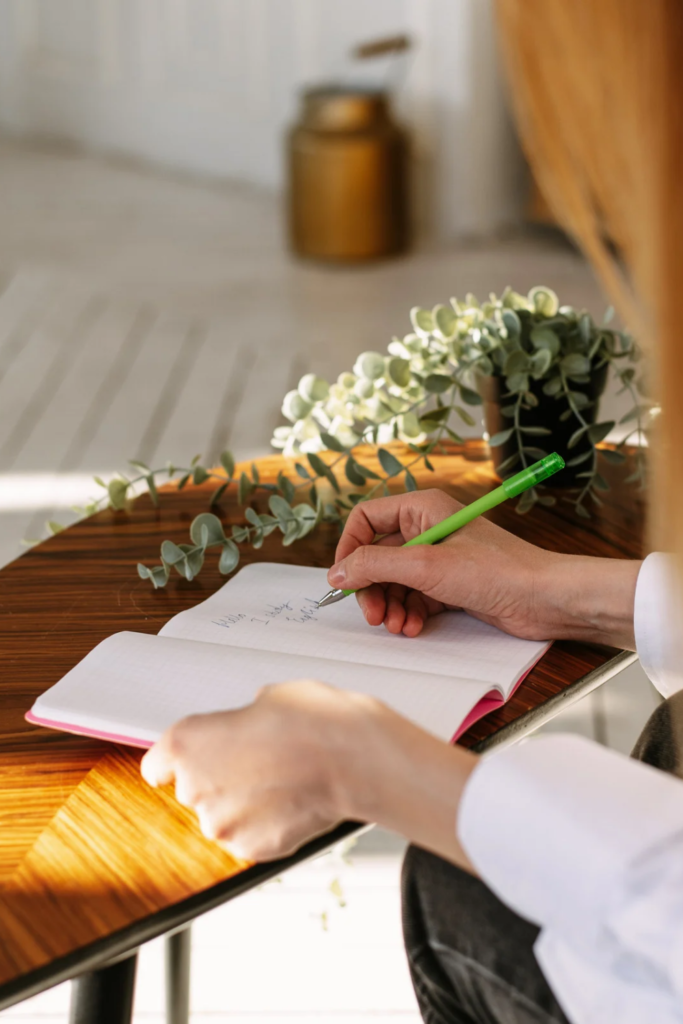 Stock photo from Canva of a Person Writing in a Journal by phkorotkova