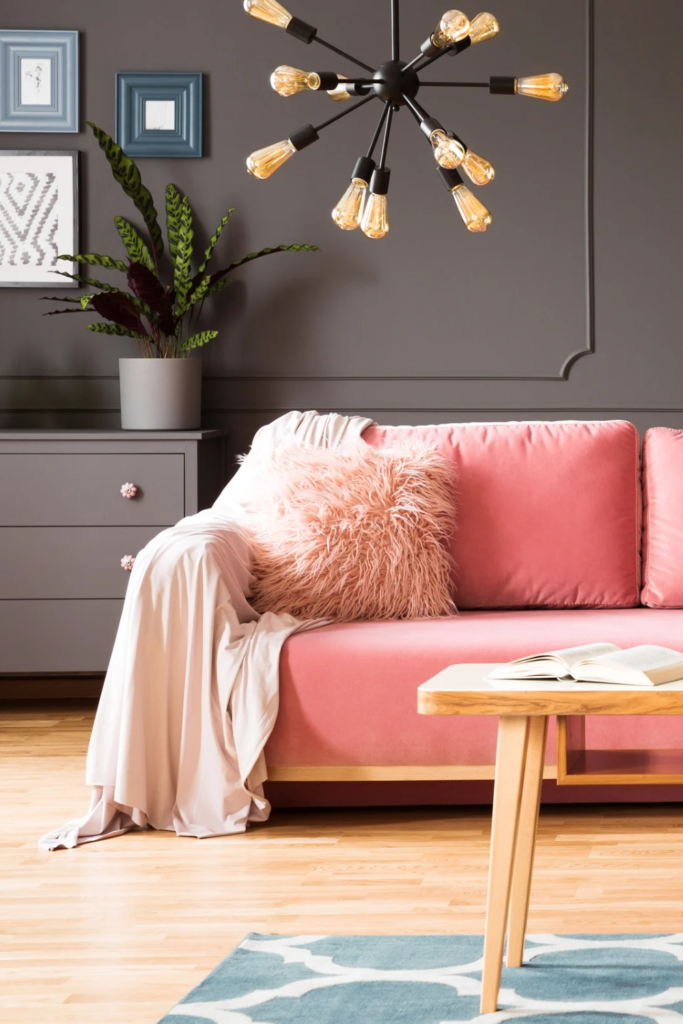 Stock photo from Canva of a bright pink couch in a grey decorated living room