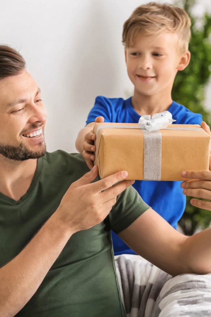 Stock photo from canva of a young boy with blonde hair and blue too giving a gift to a man with dark brown hair and a green top