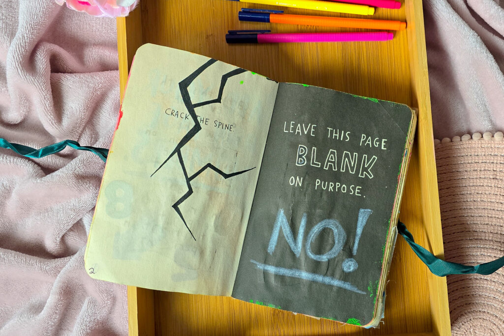 A close up photo of a page in the wreck this journal with a crack on it "Crack the spine page"
