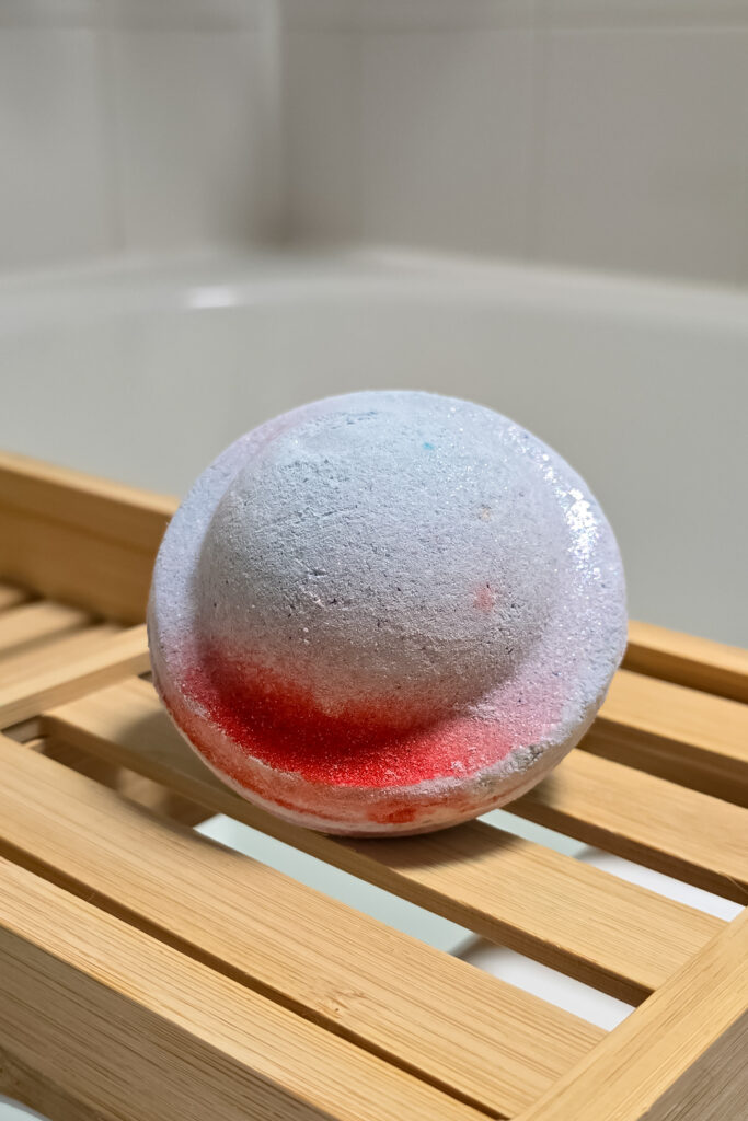 Close up photo of the Space Girl Bath Bomb from Lush on a wooden bath tray
