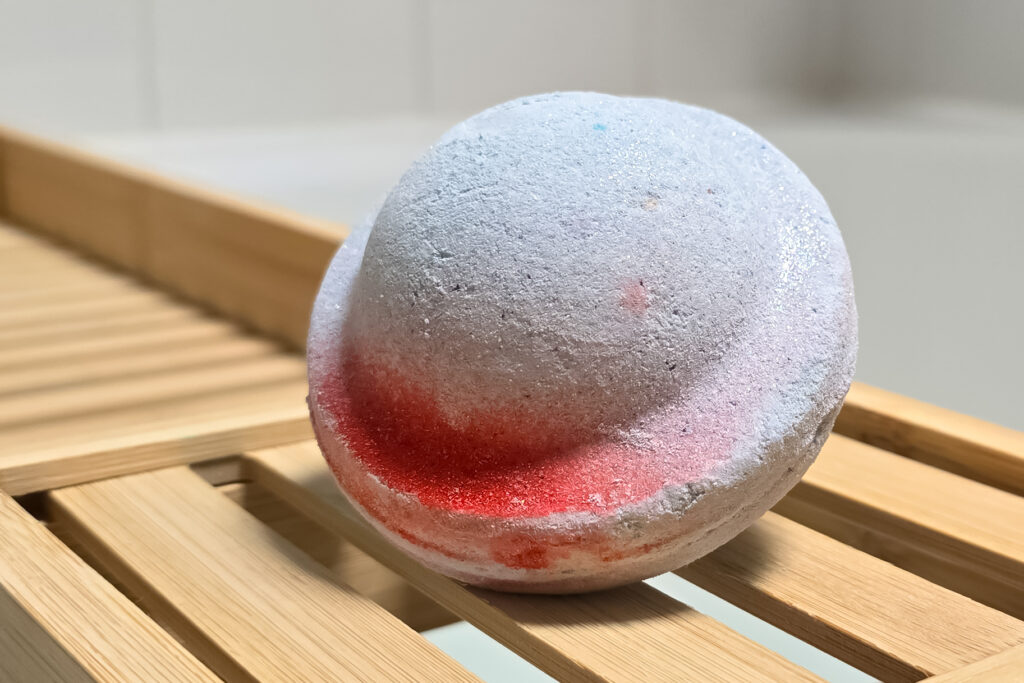 Close up photo of the Space Girl Bath Bomb from Lush on a wooden bath tray